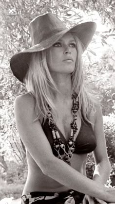 black and white photograph of a woman wearing a cowboy hat with her arms crossed in front of her chest