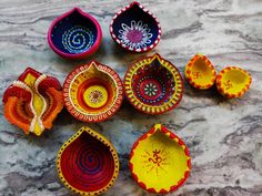 several colorful bowls sitting on top of a marble counter next to each other with designs painted on them