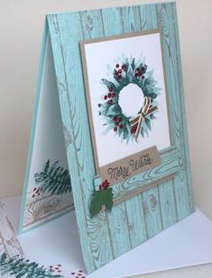 a card with a christmas wreath on the front and an easel to hold it