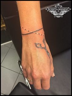 a woman's hand with a tattoo on it and a pair of scissors in the middle