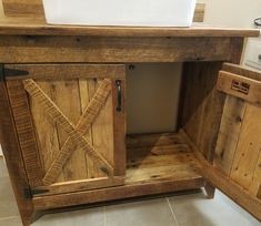 a bathroom vanity made out of pallet wood with a sink in the center and an open door on one side