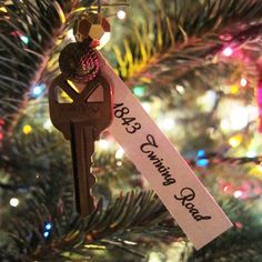 a christmas ornament hanging from the top of a tree with a key attached to it