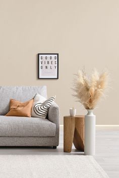 a living room with a couch, coffee table and vases on the floor in front of it