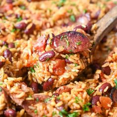 a skillet filled with rice and beans on top of a wooden spoon in it