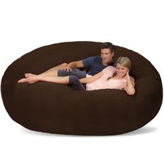 a man and woman sitting on a large bean bag chair with their arms around each other