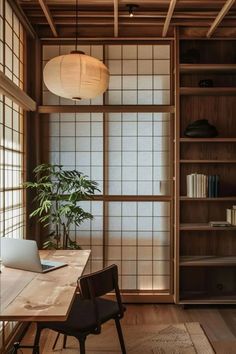 a wooden table sitting in front of a book shelf with a laptop on top of it