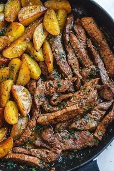 steak and potatoes in a skillet with herbs