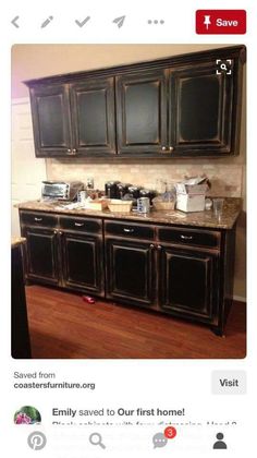 a kitchen with black cabinets and marble counter tops