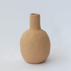 a brown vase sitting on top of a white table