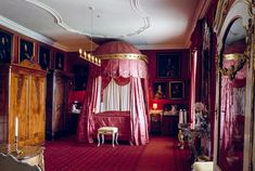 an ornate bedroom with red carpet and canopy bed