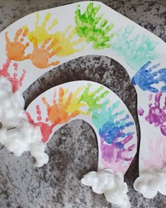 two paper plates with handprints on them sitting on a granite surface next to each other