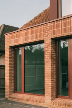 a red brick building with two windows on the outside and one window open to let in light