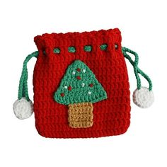 a crocheted red bag with a green tree on the front and white balls around it