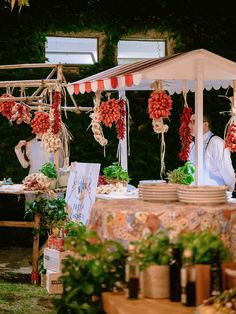 an outdoor market with lots of food and decorations hanging from it's roof,