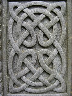 an intricate design is shown on the side of a stone wall ornament with interlocked circles