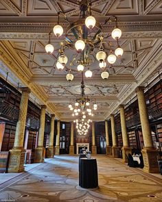 an empty library with chandeliers and bookshelves on the ceiling is pictured in this image