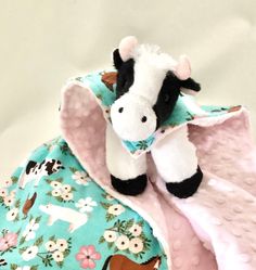 a stuffed cow laying on top of a blanket