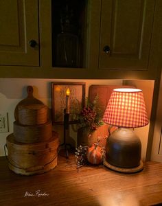 a wooden table topped with a lamp and other items