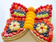 a butterfly shaped cake with fruit on top