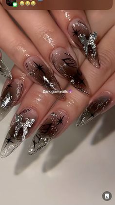 a woman's nails with silver and black designs on them