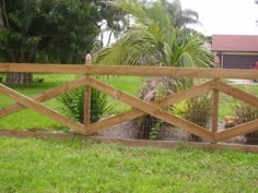 a wooden fence in front of a lush green yard