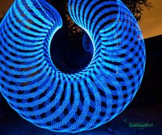 a blue circular object is lit up in the dark