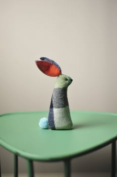 a stuffed animal sitting on top of a green table