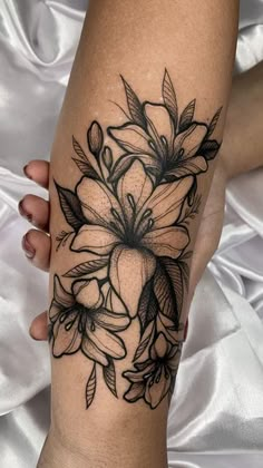 a woman's leg with black and white flowers on the side of her arm