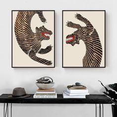 two framed art prints on a wall above a table