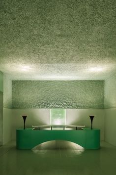 an empty room with green furniture and lights