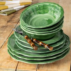 a stack of green plates with bamboo forks