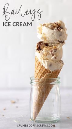 two scoops of ice cream sitting in a glass jar on a white countertop