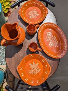 an orange dinner set on top of a wooden table