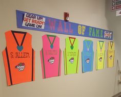 a group of colorful vests hanging on the wall next to a sign that says get ready game on