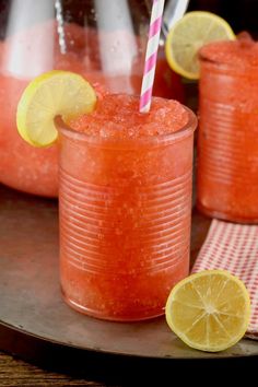 two glasses filled with watermelon and lemonade sit on a tray next to each other