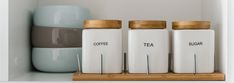 three coffee canisters sitting on top of a shelf