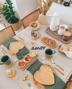 the table is set with breakfast foods and utensils