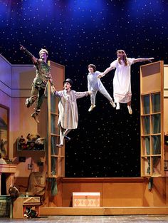 four people jumping in the air on stage