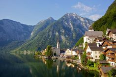 a small village on the edge of a lake surrounded by mountains