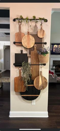 a wall mounted shelf with wooden cutting boards and potted plants on it's sides