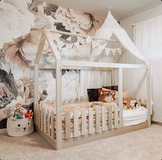 a baby's room with a white canopy bed and wallpaper on the walls