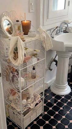 a bathroom with a sink, mirror and shelving unit next to a pedestal sink