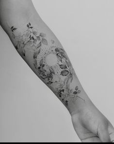 a black and white photo of a person's arm with flowers on it