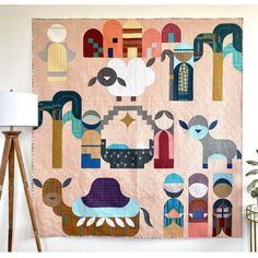 a quilt hanging on the wall next to a lamp