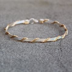 a gold and silver bracelet on the ground