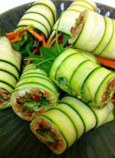 a plate with cucumber rolls and carrots on it