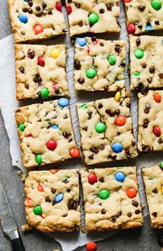 chocolate chip cookie bars cut into squares with m & m candy in the middle and on top