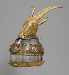 a gold and silver helmet with an animal's head sticking out of the top