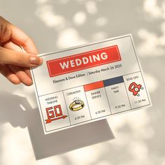 a person holding up a card with the words wedding written on it in red and white