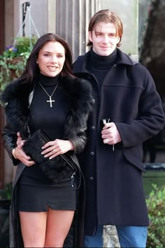 a man and woman standing next to each other in front of a building with a cross on it